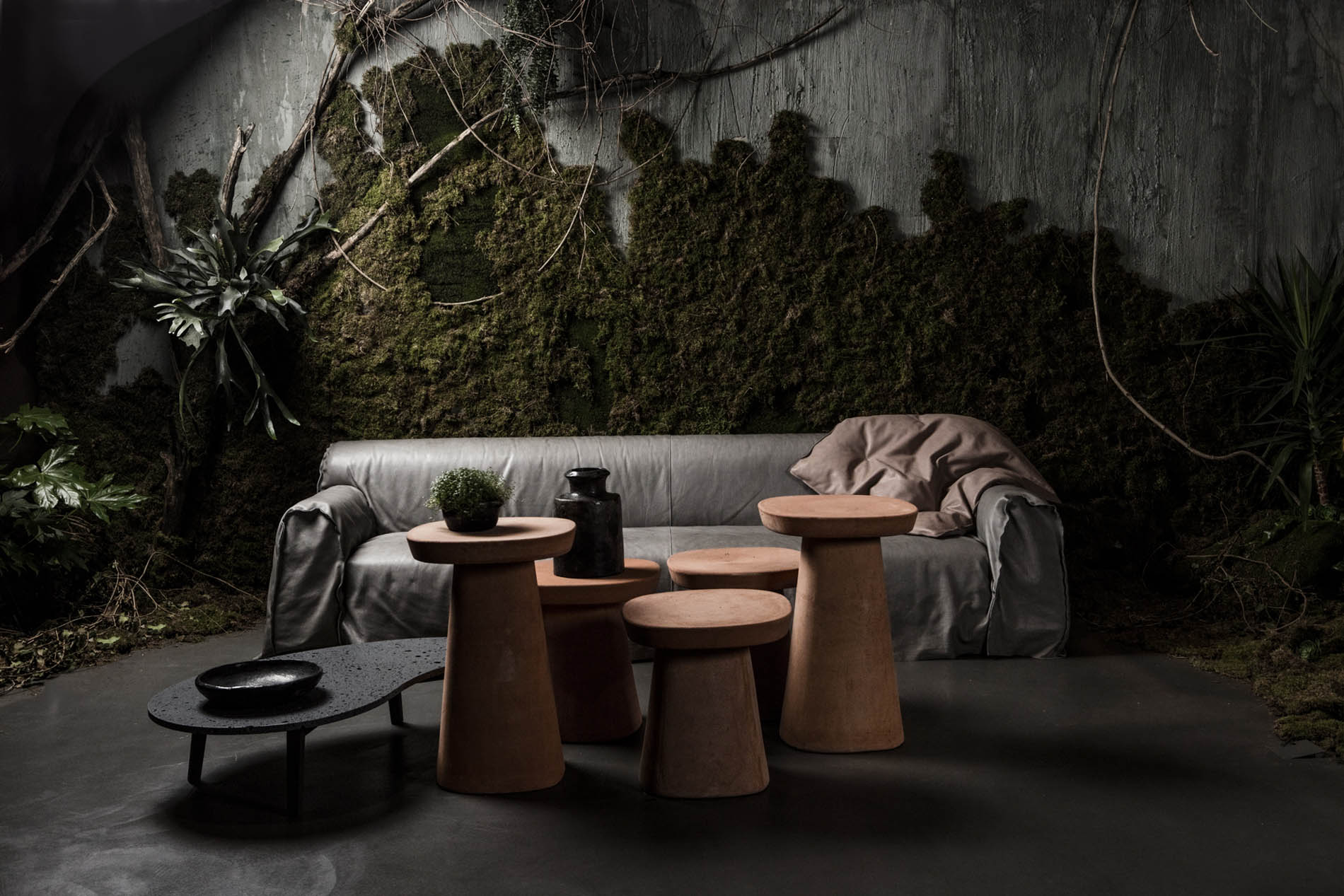 Mise en scène ScèneDeVie : canapé et tables en bois dans un décor végétal